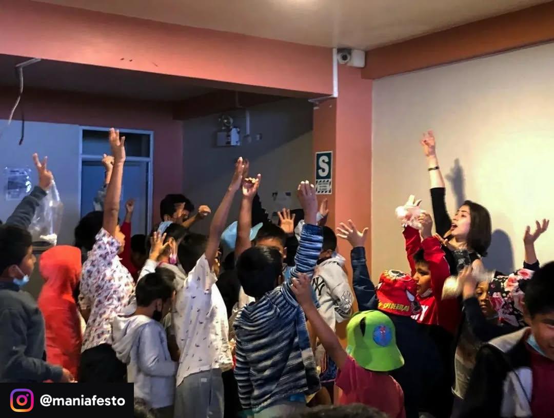 Grupo de niñas y niños celebrando con las manos en alto