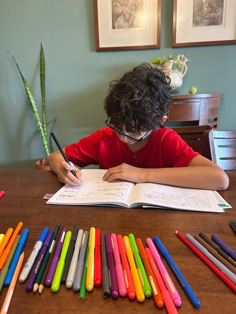 Niño dibujando con plumones de colores en su cuaderno creativo