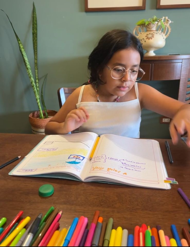 Niña explorando su cuaderno creativo en sesión