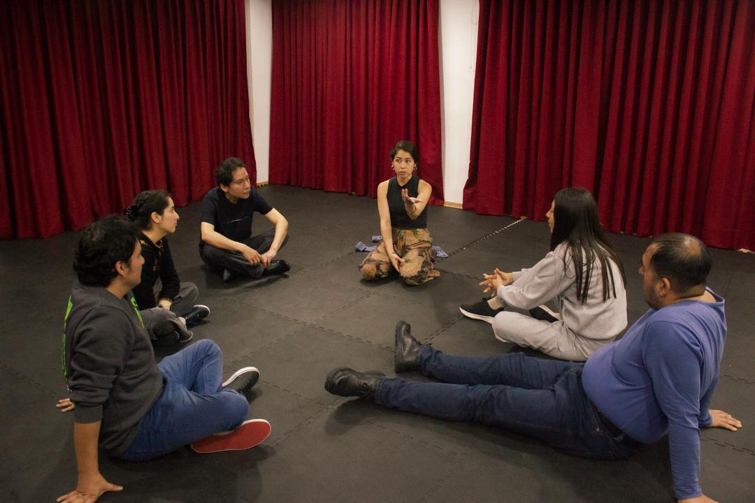 Círculo de participantes conversando en el escenario